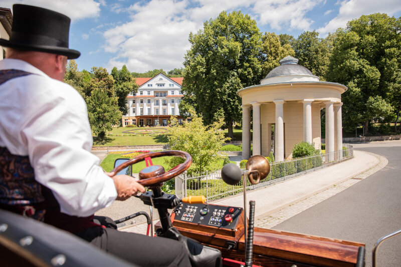 Die Bad Liebensteiner E-Kutsche fährt am Brunnentempel vorbei