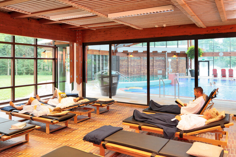 Ruheraum mit Liegen mit Blick auf das Außenbecken