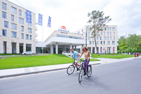 Paar auf Rädern vor dem Hotel