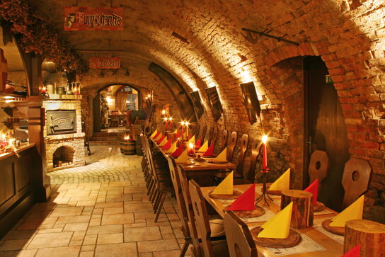 Gewölbekeller mit Tischen und Stühlen