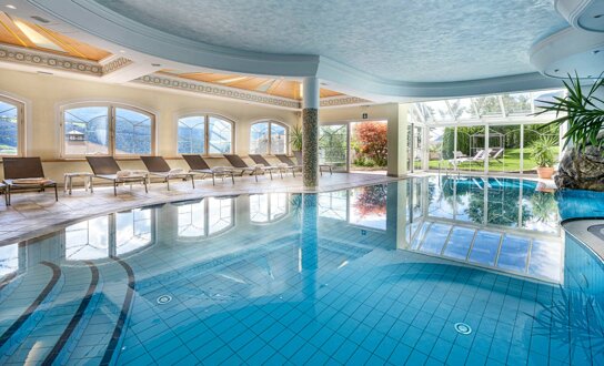 Indoorpool mit Liegen am Rand