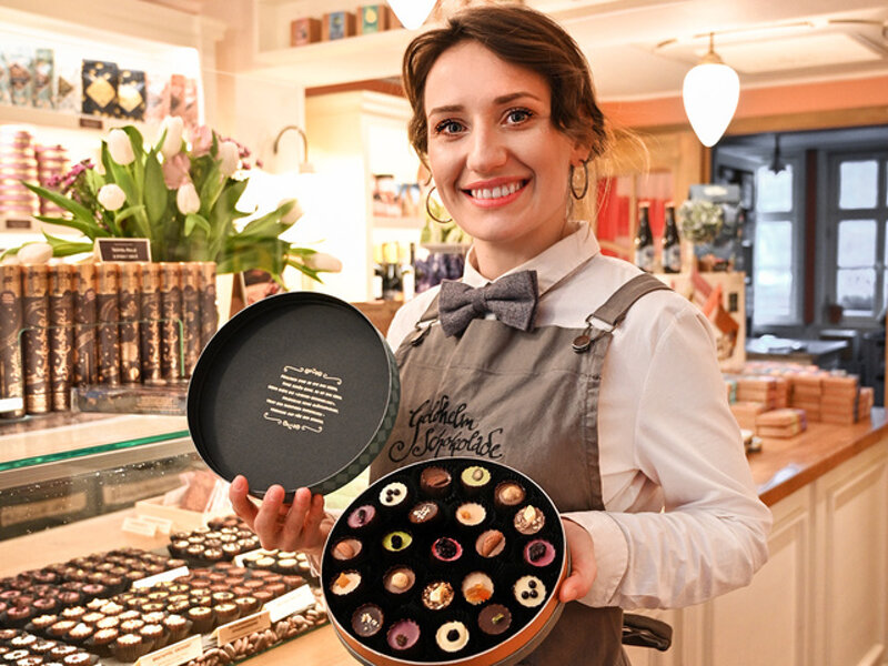 Verkäuferin präsentiert Pralinen-Box