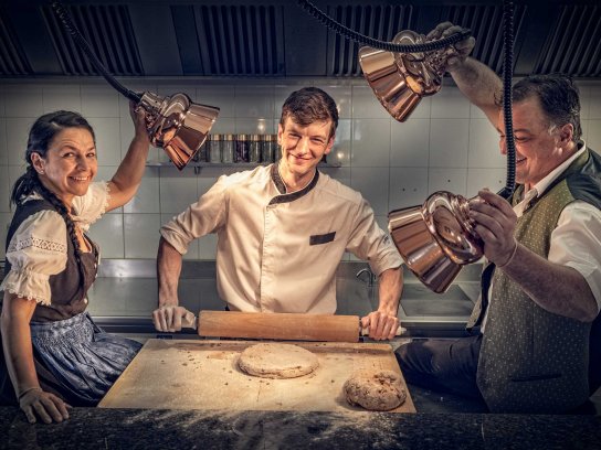 Küchenmitarbeiter am Ofen mit frischem Brot