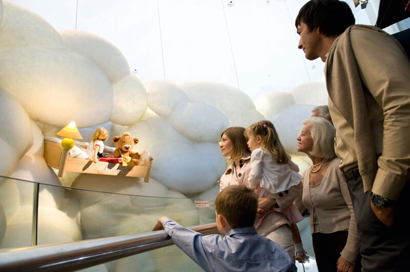 Puppe und Teddy in einem Bett