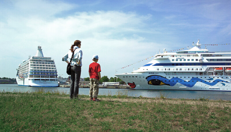 Touristen schauen auf Kreuzfahrtschiffe