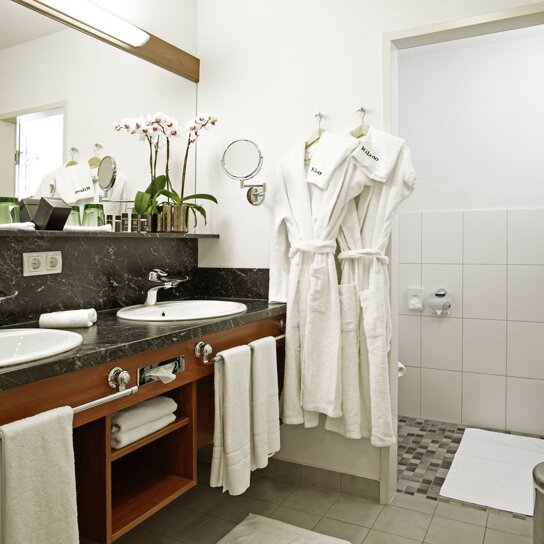 Badezimmer mit Bademantel und Doppelwaschbecken
