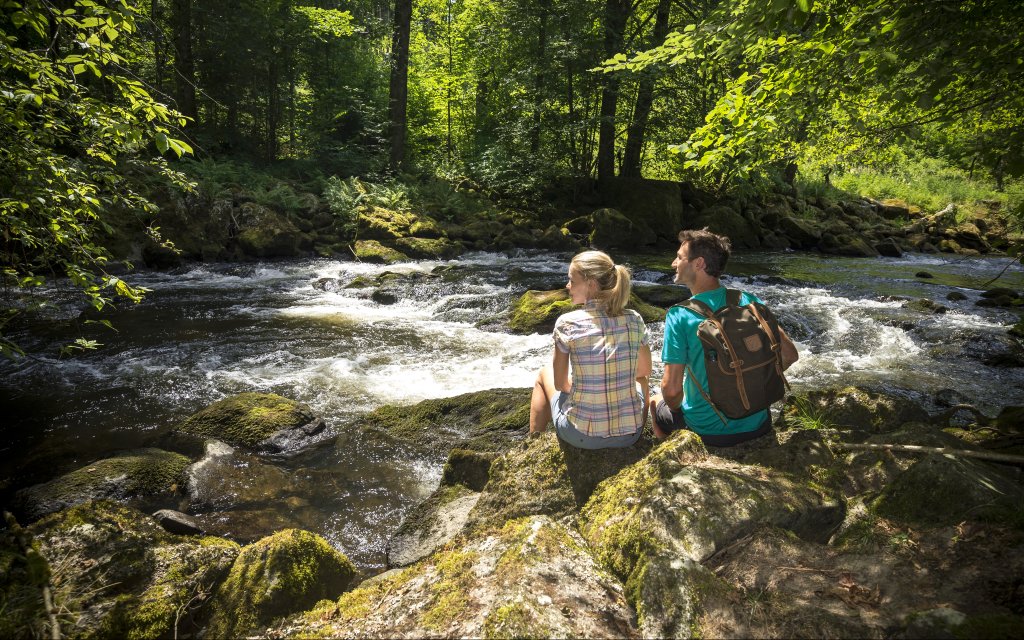 Paar an einem Bach im Bayerischen Wald