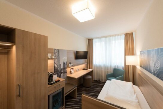 Einzelzimmer mit Schrank und Schreibtisch