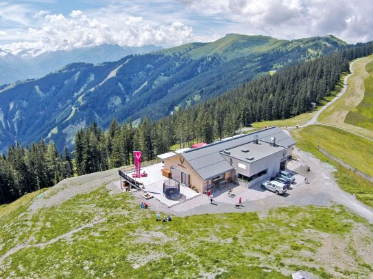 Luftbild der Schmiedhof Alm, umgeben von Bergen, Wäldern und Wiesen