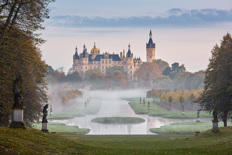Schweriner Schloss im Morgennebel über dem See