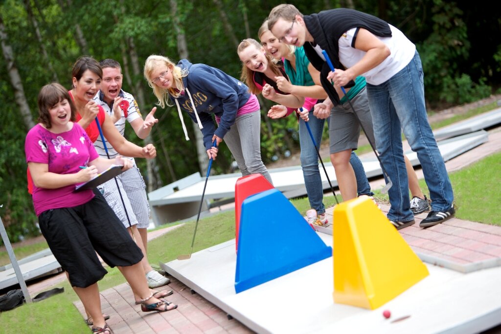 junge Personen beim Minigolf spielen