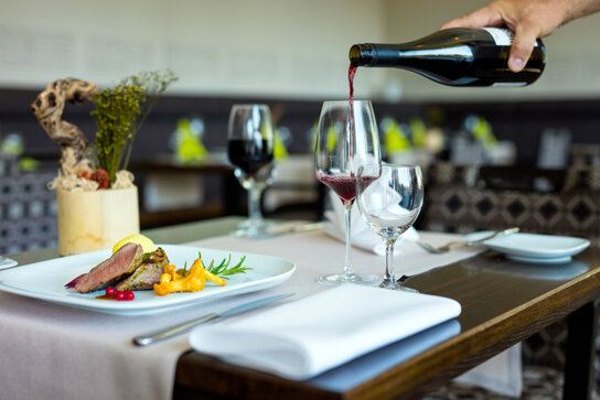 angerichtetes Essen und Weinglas mit Rotwein