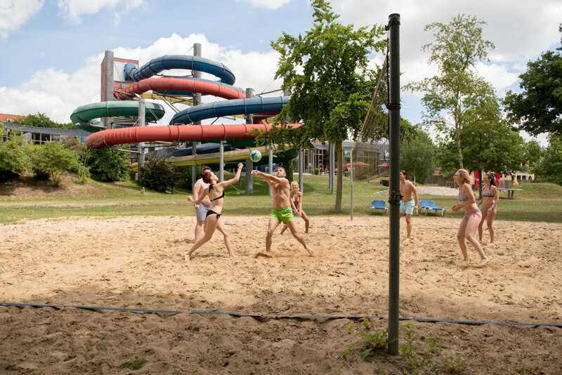 Beachvolleyballspieler vor Wassertrutschen