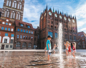 Spielende Kinder mit der Wasserfontäne auf dem Alten Markt vor dem Rathaus playing Children in front of the town hall c Erik Hart - Tourismuszentrale Stralsund
