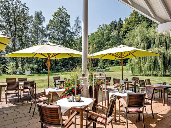 Terrasse mit Sonnenschirm und Stühlen