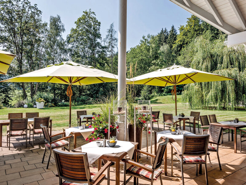 Terrasse mit Sonnenschirm und Stühlen
