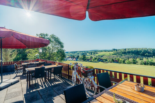 Terrasse mit Sonnenschirmen und Tischen