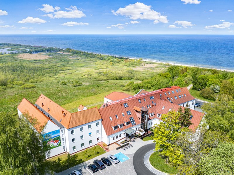 Blick von oben auf das Hotel Mona Lisa Boutique Wellness & Spa mit der Ostsee im Hintergrund