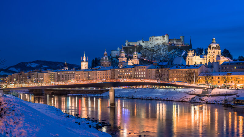 Salzburg bei Nacht mit Blick auf die Festung Hohensalzburg und den Fluss