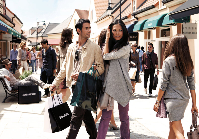 Junges Paar beim einkaufen im Outlet La Vallée Village