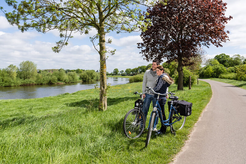 Pärchen mit Rädern an einem Fluss durch die Lüneburger Heide