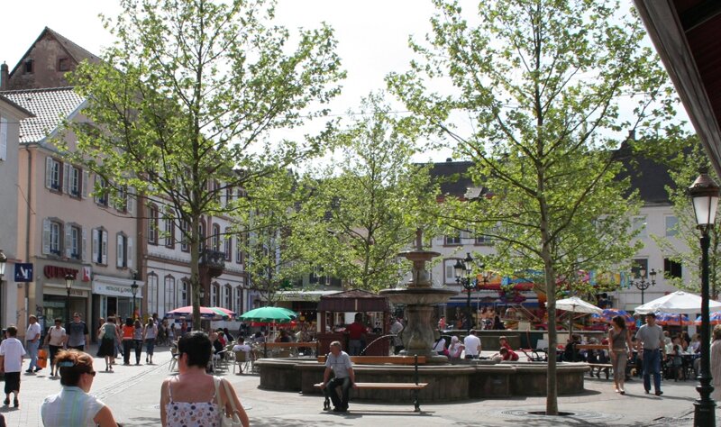 Platz in der Innenstadt mit Bäumen und Menschen