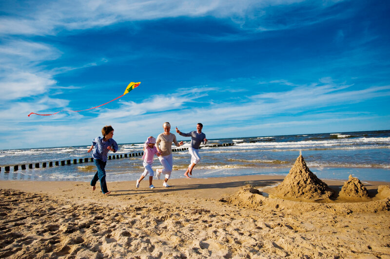eine Familie lässt Drachen steigen am Strand von Usedom