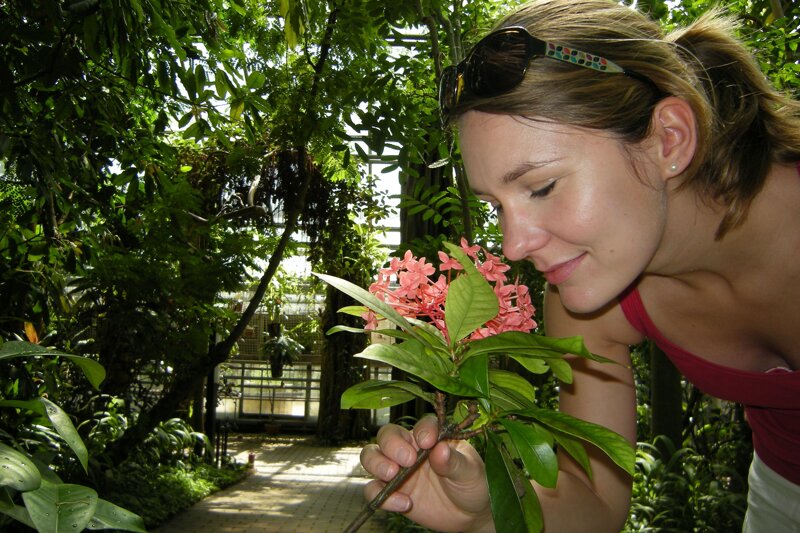 Frau riecht an Blüte im botanischen Garten Liberec