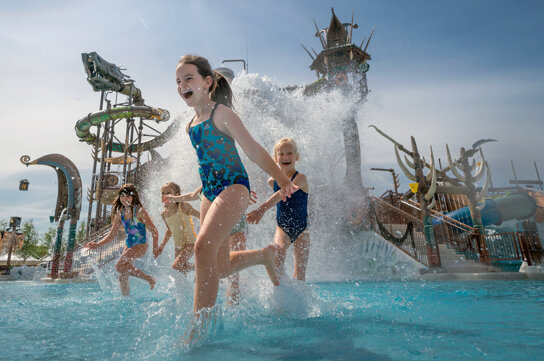 Kinder spielen vor Rutschen