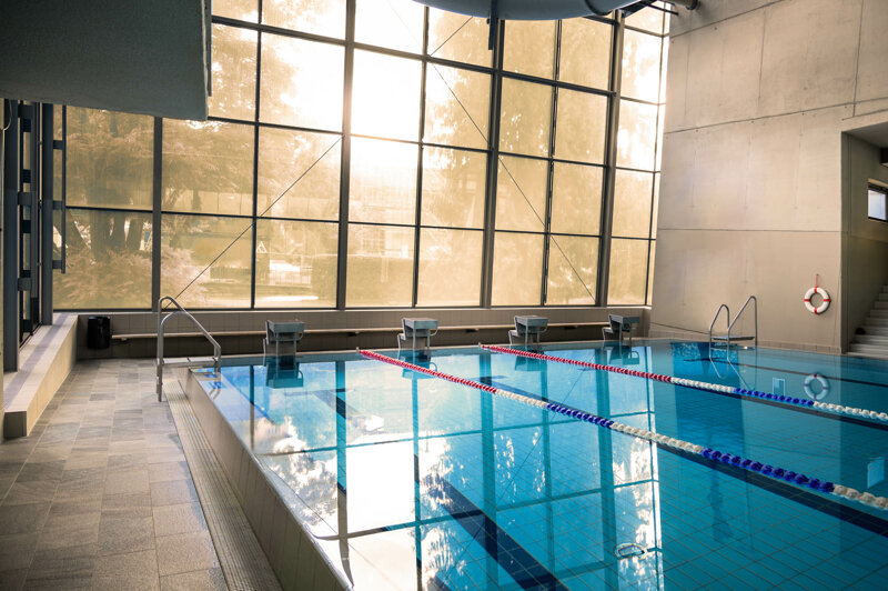 Schwimmbecken mit Fensterfront