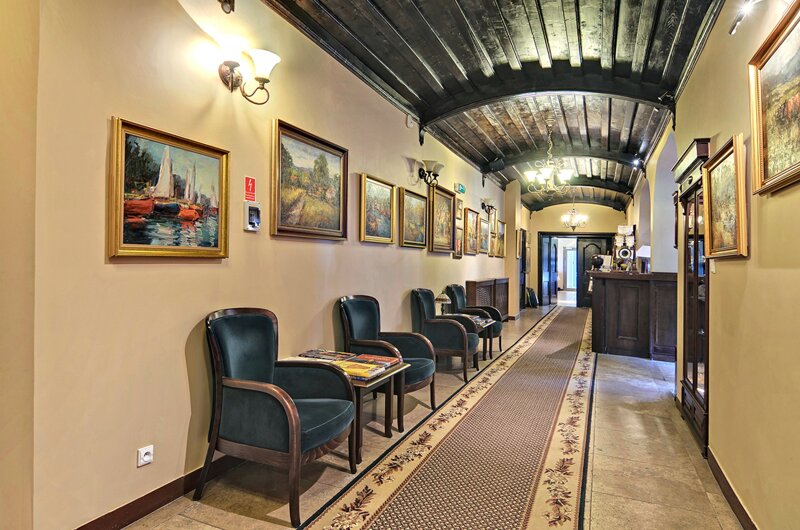 Flur des Hotel Mona Lisa Boutique Wellness & Spa mit Sesseln und Ölbildern