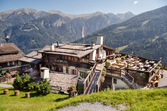 Blick von oben auf die Alm Bellevue mit den Bergen rings herum