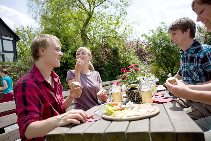 Männergruppe beim Kurzurlaub im Biergarten – Reisen verschenken als Geschenkidee