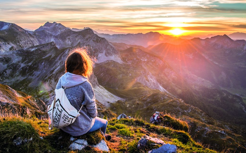 Frau betrachtet Sonnenuntergang in Obertauern