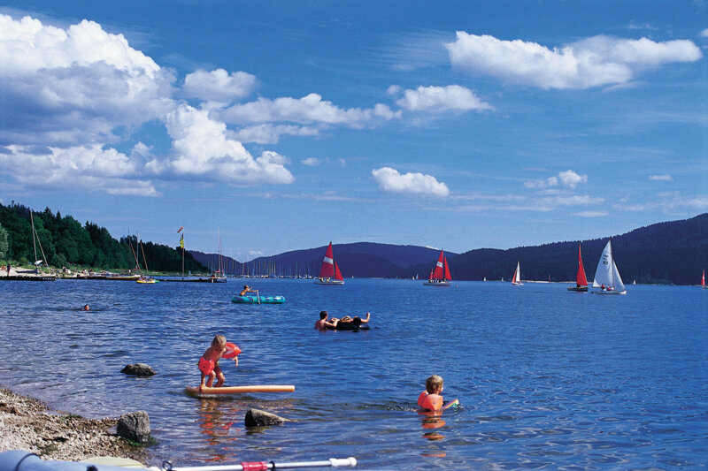 Schwimmer und Segelschiff auf dem Schluchsee