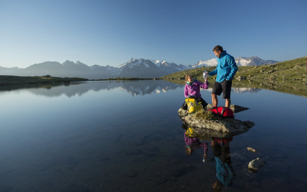 Paar macht eine Wanderpause vor einem See im Ötztal