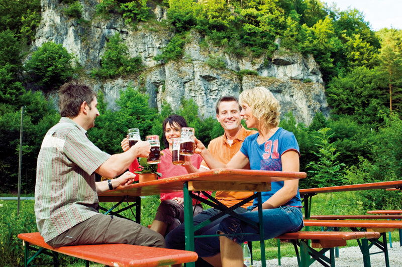 Menschen sitzen am Tisch und trinken Bier