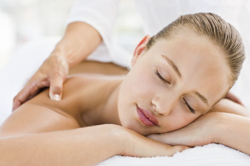 Eine völlig entspannte Frau, die mit geschlossenen Augen ihre Massage genießt
