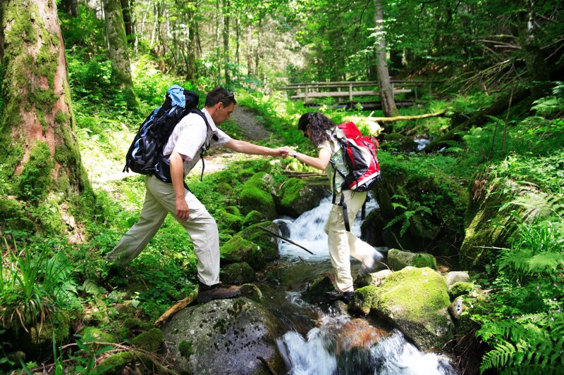 Wanderer überqueren einen Bach