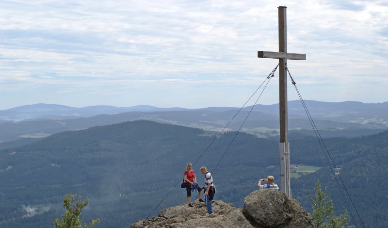 Wanderer am Gipfelkreuz auf dem Silberberg