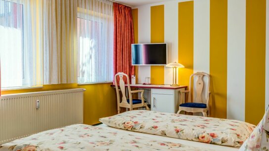 Doppelzimmer mit gestreiften Wänden