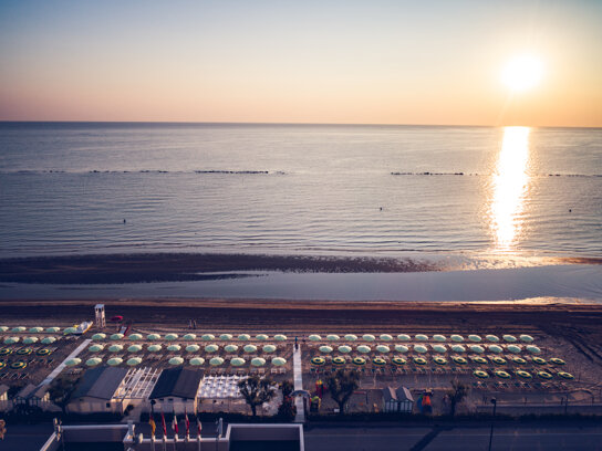 Strand mit Sonnenschirm von oben