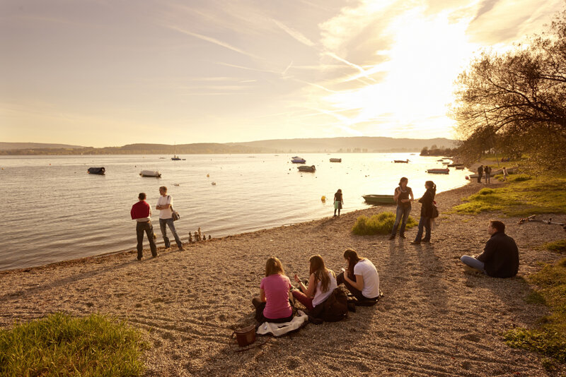 Menschen am Sandufer des Bodensees
