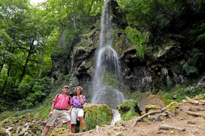 Wanderer am Uracher Wasserfall – Blick auf den Wasserfall