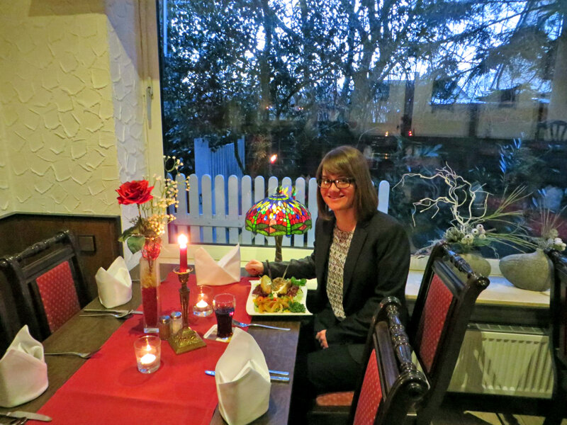 Melanie Schmitt sitzt bei Kerzenschein im Restaurant an einem Fenster