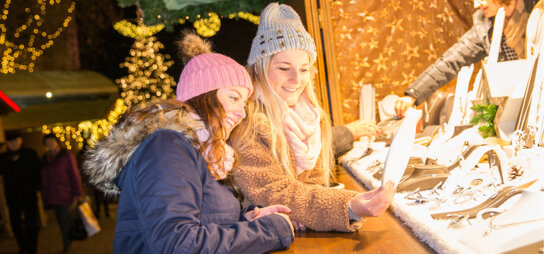 Frauen an einer Weihnachtsmarktbude