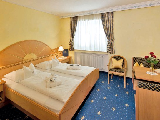 Doppelzimmer mit blauem Teppich