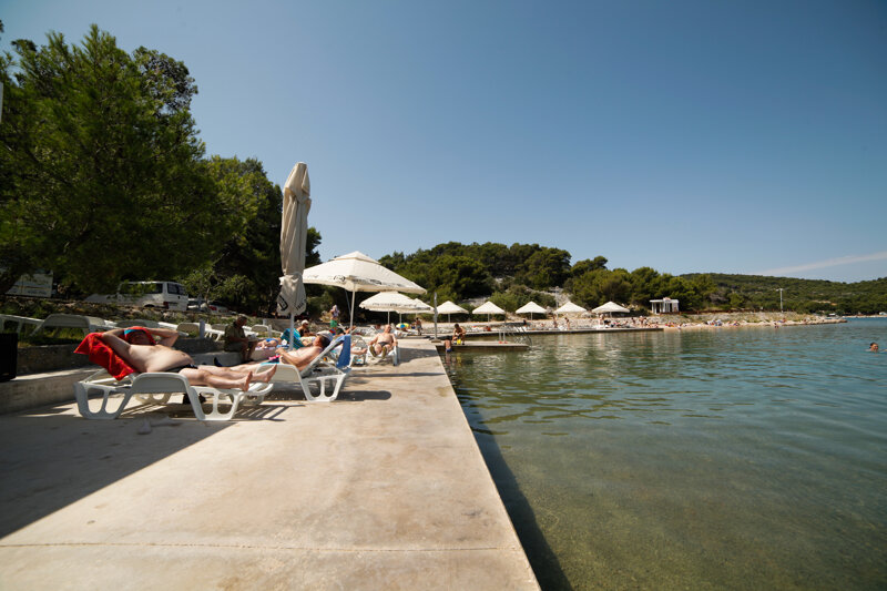 Strand mit Schirmen und Liegen