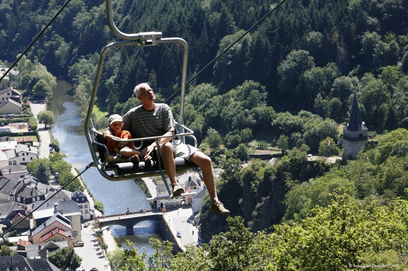 Vater und Kind im Sessellift über das Ourtal
