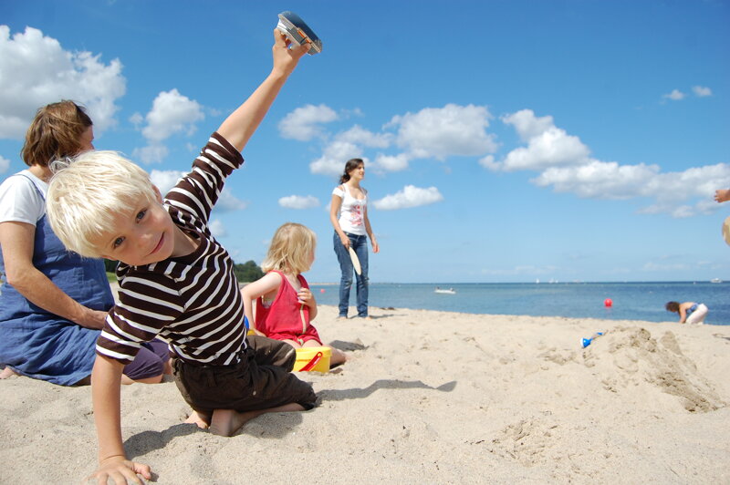 Kind spielt am Strand – Familienurlaub an der deutschen Küste